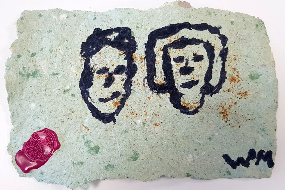 homemade paper with two faces and a wax seal