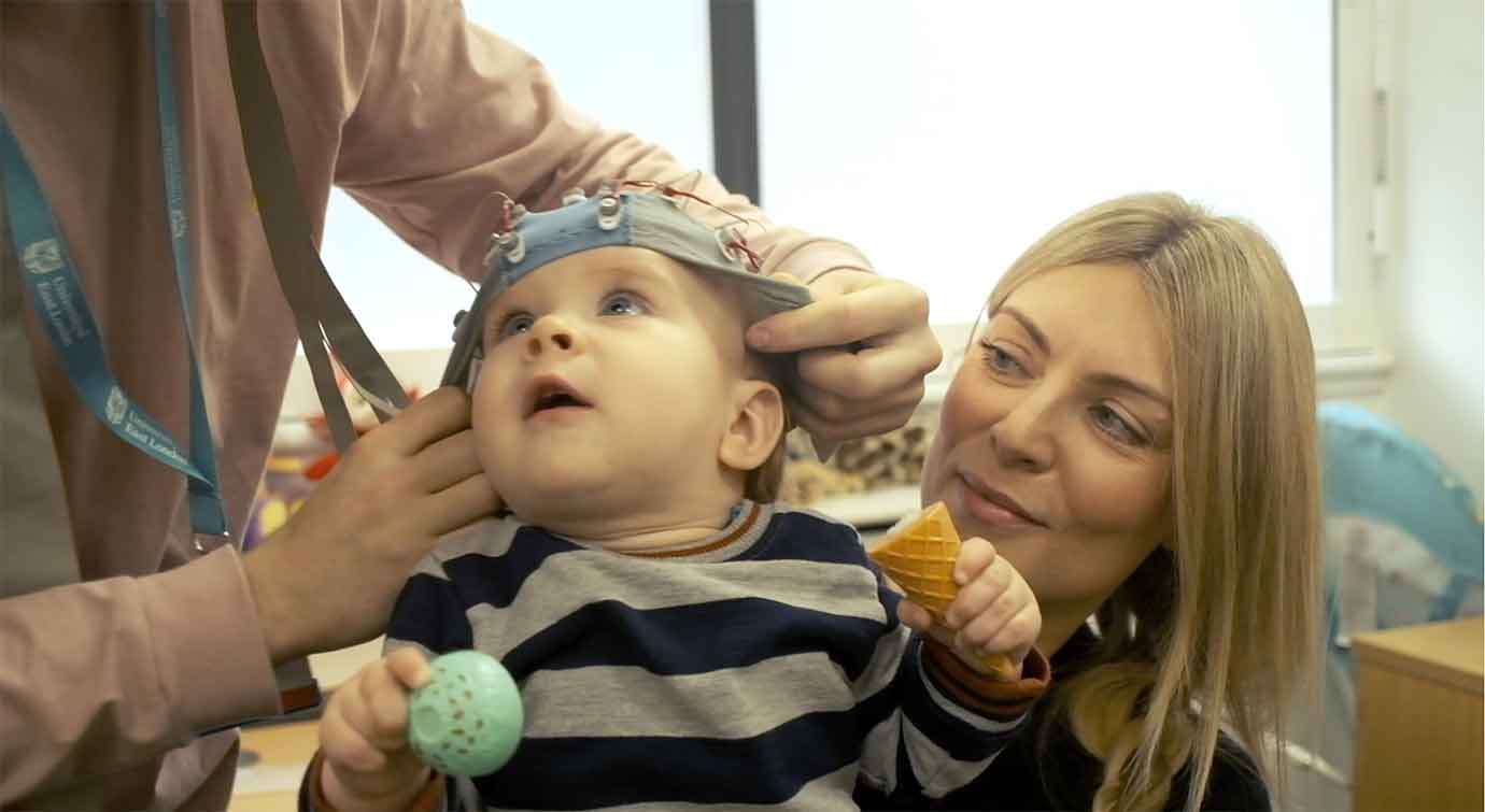 woman holding child wearing head tracker