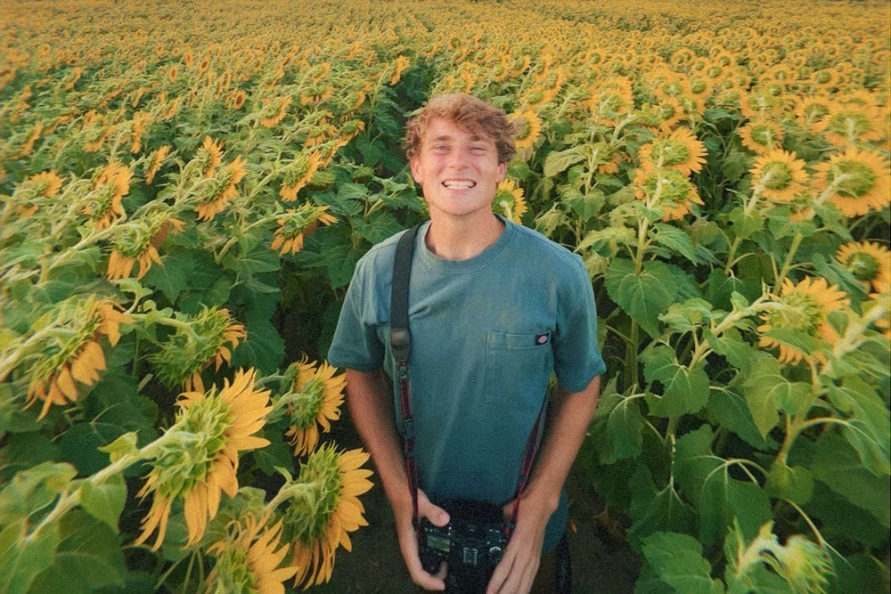young man in field of sunflowers