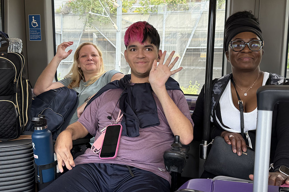 3 students waving goodbye