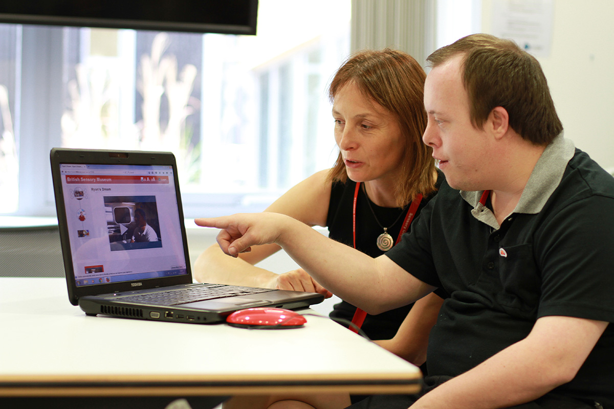 Young person and supporter using laptop