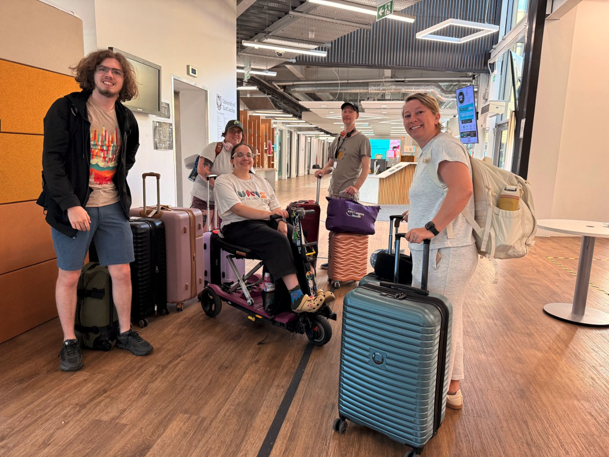 group of young people standing and sitting with suitcases